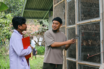 Happy Farmer Opens Chicken Coop for Vet Inspection © Gatot