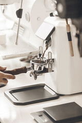 Professional Barista Skillfully Pouring Freshly Ground Coffee Into Portafilter for Espresso Preparation, Close-up