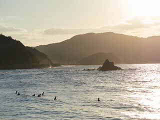 福岡県糸島市大口海岸の美しい夕日の風景とサーフィンする人々の姿