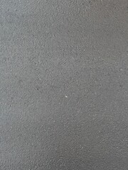 Dark wet asphalt pavement with a rough texture, viewed from above. Outdoor roadway background. Urban construction and road materials concept. Textured photo.