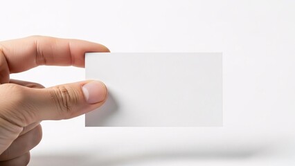 A hand holding a small white blank card or paper