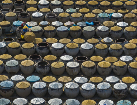 Aerial view of hundreds of jars, some topped with yellow lids and others with silver, create a textured tapestry, Phan Thiet, Binh Thuan, Vietnam.