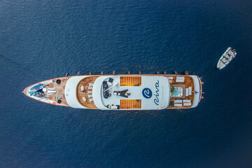 Pomena, Croatia - 25 September 2025: Aerial view of a Riva yacht cutting through the deep blue Adriatic waters, its crisp white superstructure contrasting with the warm teak decks.