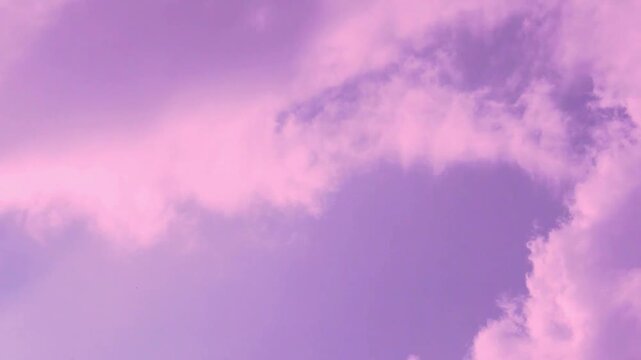 Lilac purple morning sky puffy fluffy colored clouds in sunlight fast time lapse, air plane window view, aerial drone view. Amazing sunrise scyscraper colored cloudscape color atmosphere dawn sky.