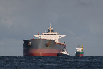 Naklejka premium MARITIME TRANSPORT - A large bulk carrier is sailing into sea port