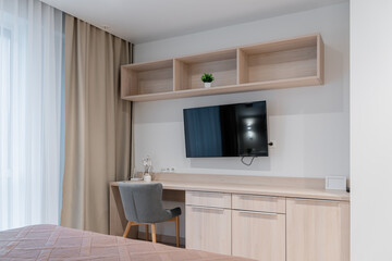 Modern Bedroom Workspace with TV and Light Wood Furniture