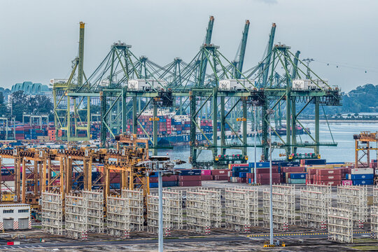 Singapore, Singapore - 07 November 2025: Aerial view of a bustling port at Tanjong Pagar Terminal, where towering cranes loom over stacks of colorful shipping containers.