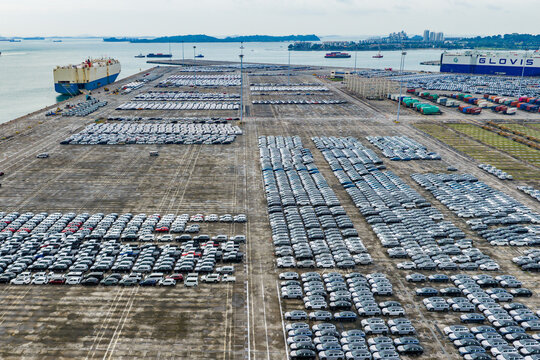 Singapore, Singapore - 07 November 2025: Aerial view of the PSA Tanjong Pagar Terminal, where rows of cars meet the sea, creating a stark contrast of industrial precision against the ocean's vastness.