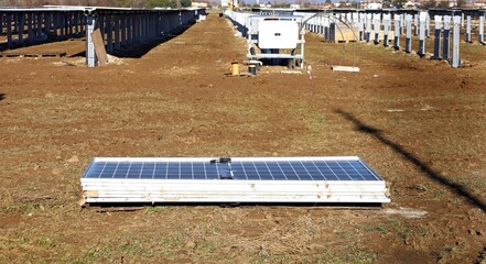 Stack of solar panels  on the ground during the construction of a new photovoltaic field in the countryside