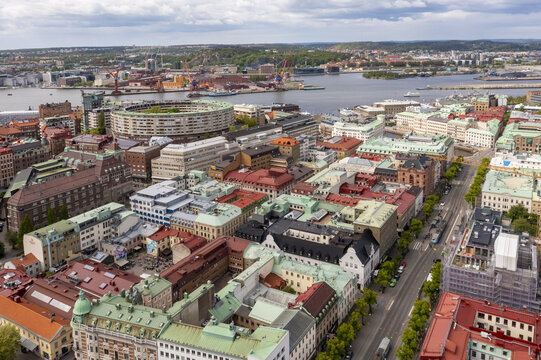 Aerial view of the vibrant cityscape, where terracotta roofs meet the shimmering waters near the Gothenburg Opera and the port's industrial cranes, Gothenburg, Vastra Gotaland County, Sweden.