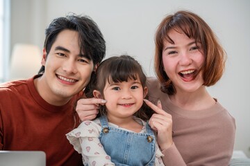 Family enjoys time together at home with smiles and laughter in a cozy living room setting during the afternoon