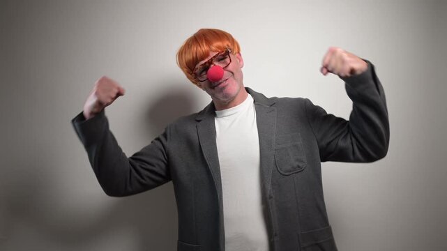 Funny clown businessman showing muscles and dancing
