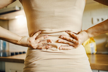 Woman suffering from lower back pain at home