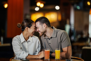 Happy interracial couple enjoying a romantic date at a restaurant