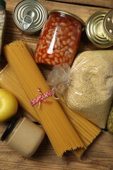 Humanitarian aid. Different food products for donation in crate on wooden table