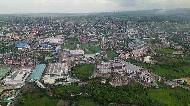 Aerial establishing shot of the commercial district area and buildings amid greenery at Camarines Sur, Bicol, Philippines.