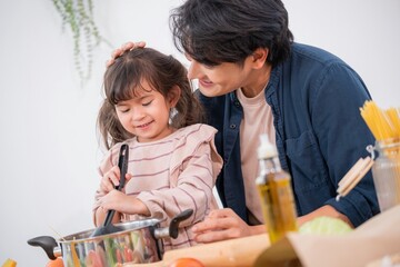 Obraz premium Father and daughter cooking together in a kitchen while stirring a pot of food in the afternoon