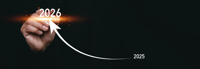 Naklejka na ściany i meble A hand drawing an upward arrow from 2025 to 2026, symbolizing future growth, business progress, strategic planning, success, and positive financial forecast