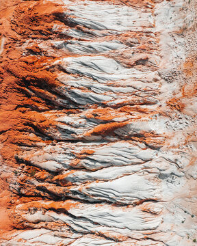 Aerial view of contrasting red cliffs meet the pale sands, creating a striking natural division, Praia da Falesia, Faro District, Algarve, Portugal.