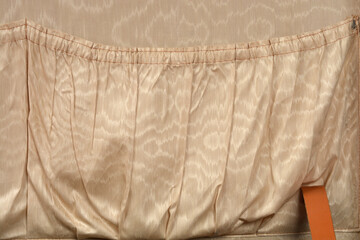 A horizontal close-up shot shows the gathered, elasticized top seam of the beige satin interior lining pocket of a vintage suitcase