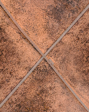 Aerial view of geometric patterns formed by terracotta tiles with contrasting grout lines creating a textured surface, Algarve, Faro District, Portugal.