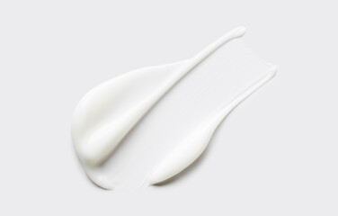 cosmetic smear of creamy texture on gray background