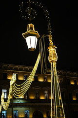 Ornate Street Lamp Adorned with Golden Lights at Night