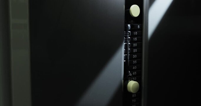 Close-up of a gym machine in action in a ray of light.