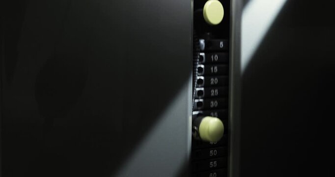 Close-up of a gym machine in action in a ray of light.