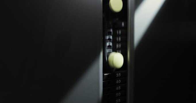 Close-up of a gym machine in action in a ray of light.