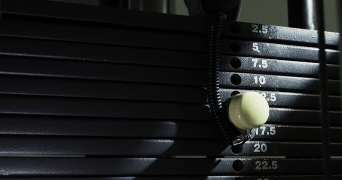 Close-up of a gym machine in action in a ray of light.