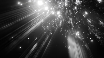 Abstract background showing bright glowing particles exploding and shining down with strong light rays, creating a mysterious and energetic visual effect in grayscale