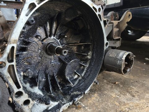 Greasy Internal View of a Dirty Mechanical Component: A Close-up of a Metal Transmission Housing or Engine Part Covered in Thick Black Oil Sludge and Grime, Needing Maintenance and Repair