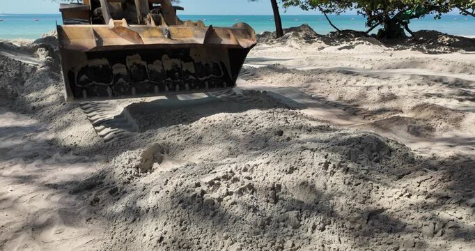 close up of a loader bucket moving sand for beach nourishment.