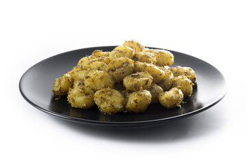 Gnocchi with pesto sauce served on black plate isolated on white background