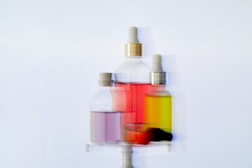 Modern Glass Dropper Bottles with Colorful Serums on Reflective Surface with Dynamic Motion Blur Background