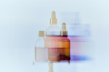 Modern Glass Dropper Bottles with Colorful Serums on Reflective Surface with Dynamic Motion Blur Background