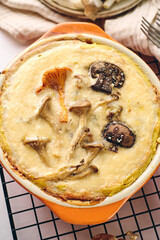 Quiche with chanterelle mushrooms, oyster mushrooms, button mushrooms, and cheese in two serving dishes