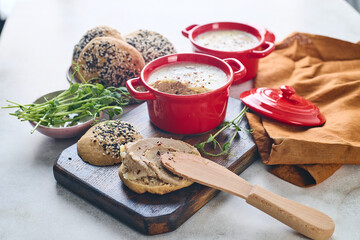 Gourmet Liver Pate Appetizer with Sesame Seed Bagels and and Fresh Pea Shoots on Rustic Wooden Board