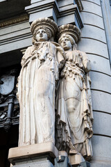 Stone statues at the entrance of The Caryatid building in Madrid city
