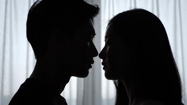 Silhouettes of a young couple facing each other, symbolizing intimacy and connection.
