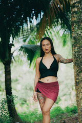 Woman in tropical forest posing by tree, confident stance and jungle environment with natural light and earthy tones