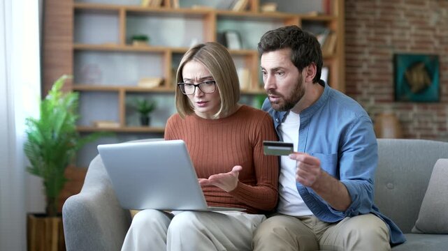 Upset married couple became a victim of deception and fraud after checking credit card on laptop at home. Disappointed husband and wife have problems with bank transfer transaction or have lost money