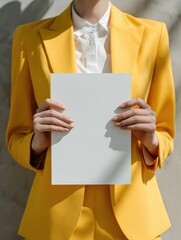 Elegant Woman Holding Poster in Vibrant Yellow Suit
