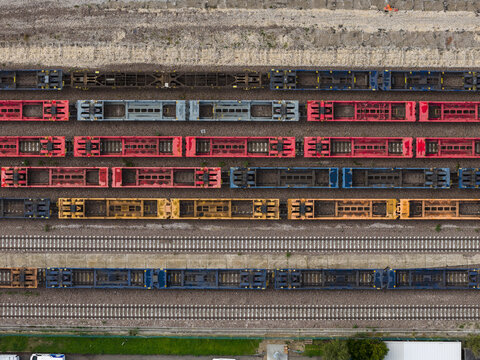Aerial view of colorful train cars lined up on tracks, creating a geometric pattern, Trieste, Italy.