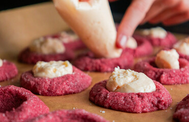 Filling Red Velvet Thumbprint Cookies with Cream Cheese in Tray