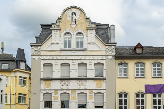 View of intricate architecture with detailed facades, contrasting colors, and textured surfaces under a cloudy sky, Koblenz, Rhineland-Palatinate, Germany.