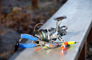 Fishing reel and tackle on wooden railing © Olena Smerichka