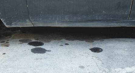 Black engine oil on concrete floor.