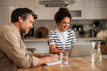 Casual Home Office Meeting With Laptop at Kitchen Table Between Colleagues